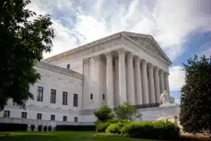 Supreme Court building with columns under cloudy sky.